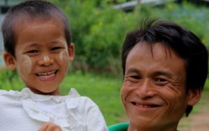 A happy father holds his daughter in Myanmar.