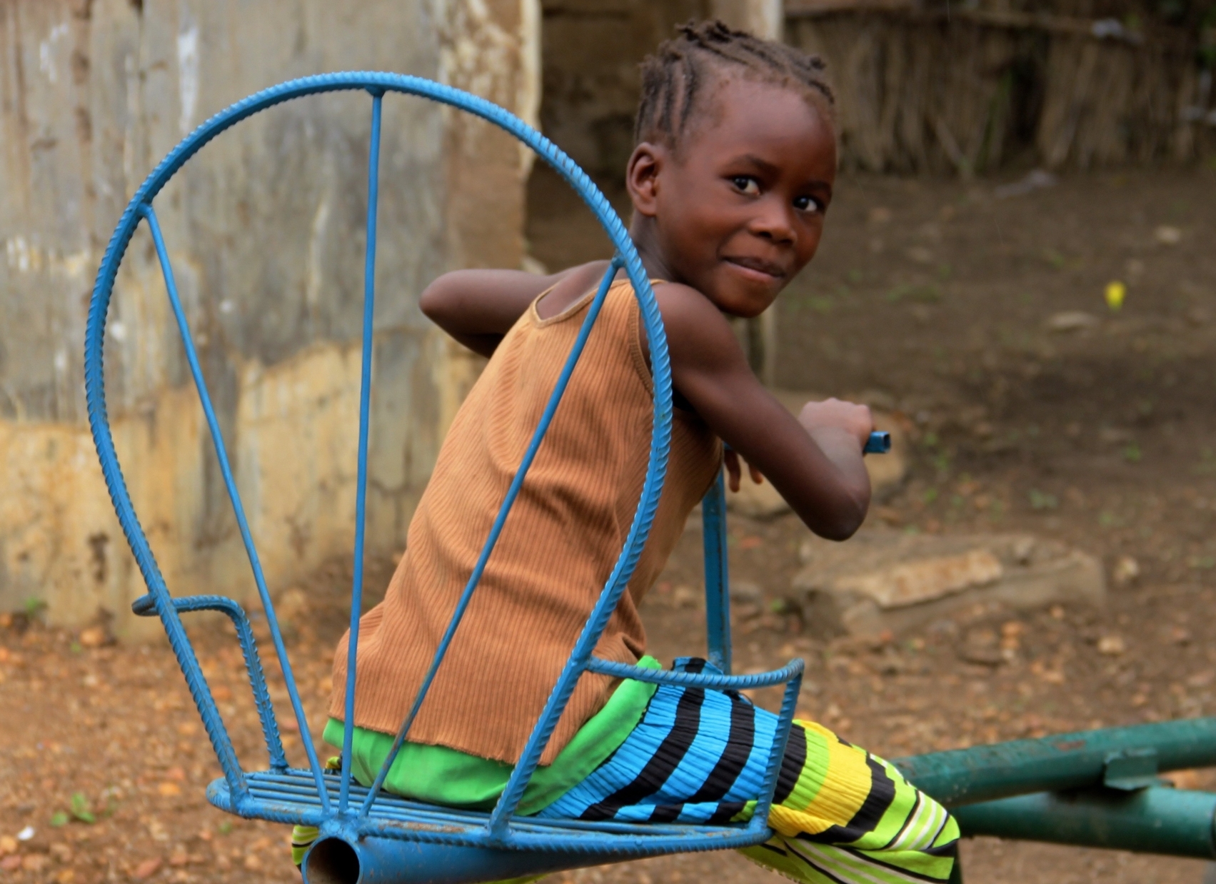 Young girl enjoys seesaw in Kenya.