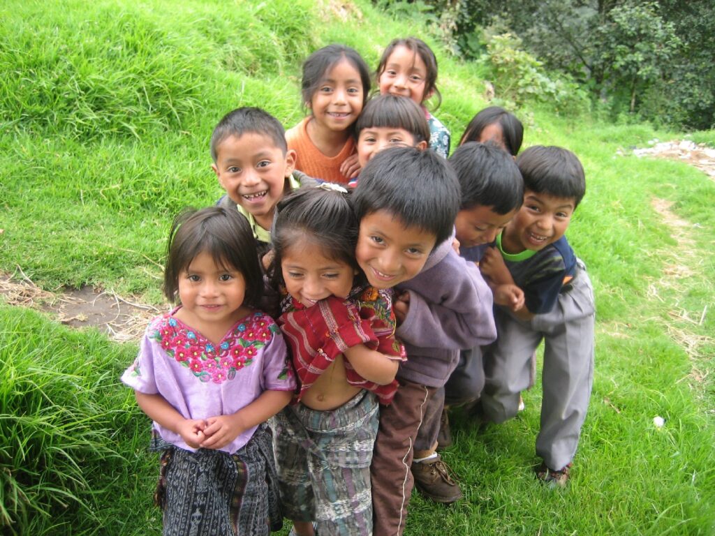 In Guatemala, a group of young children smile at the camera.