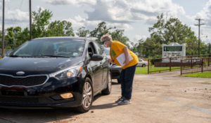 Volunteers for the Episcopal Church in Western Louisiana hand out bottled water and gift cards to the local grocery store to local residents still affected by last year’s Hurricane Laura and Hurricane Delta at Evergreen Missionary Baptist Church in DeQuincy, Louisiana on July 17, 2021.