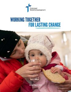 A mother holds a glass up to a young child's mouth. Both are wearing winter jackets and hats. Above them is the Episcopal Relief & Development logo and the title "Working Together for Lasting Change." Under them are the words "Annual Report 2022"
