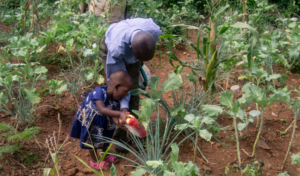 Awiti and her father, Bon, in their garden.