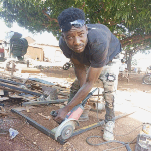  Jerry works on a motorcycle stand using an angle grinder to make cuts.